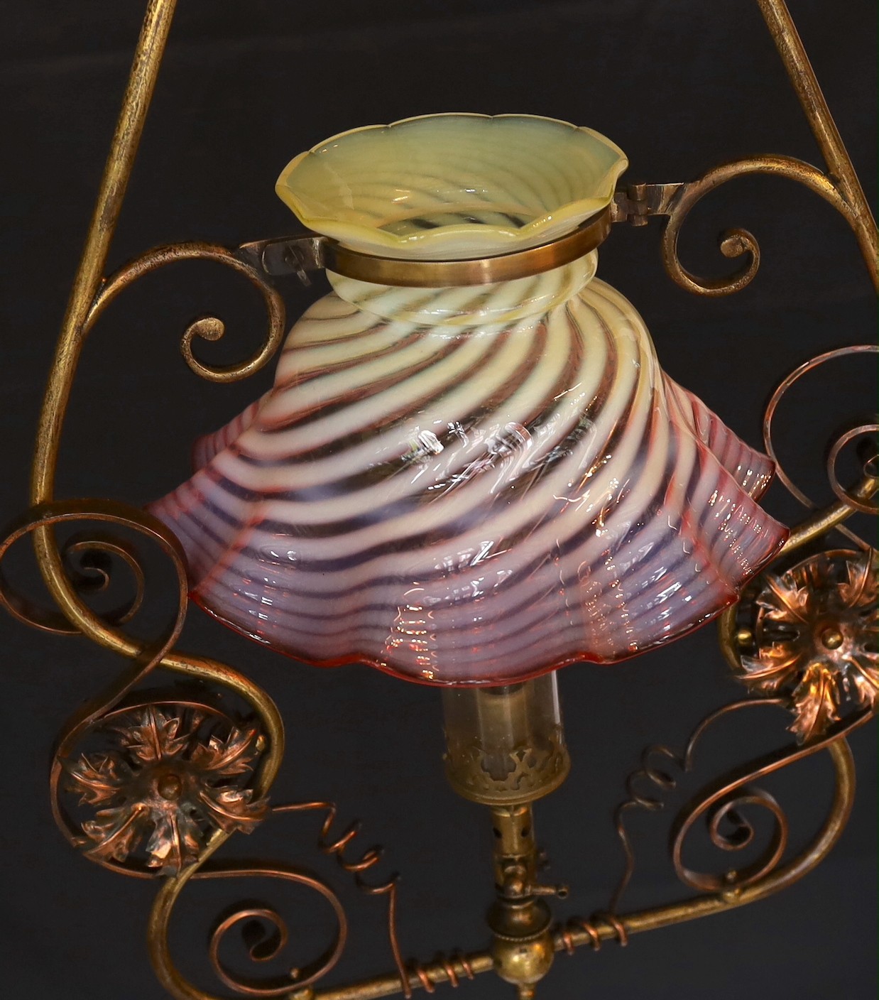 An English Arts & Crafts lacquered brass and copper gasolier with red tinted Vaseline glass shade, height 80cm. width 40cm